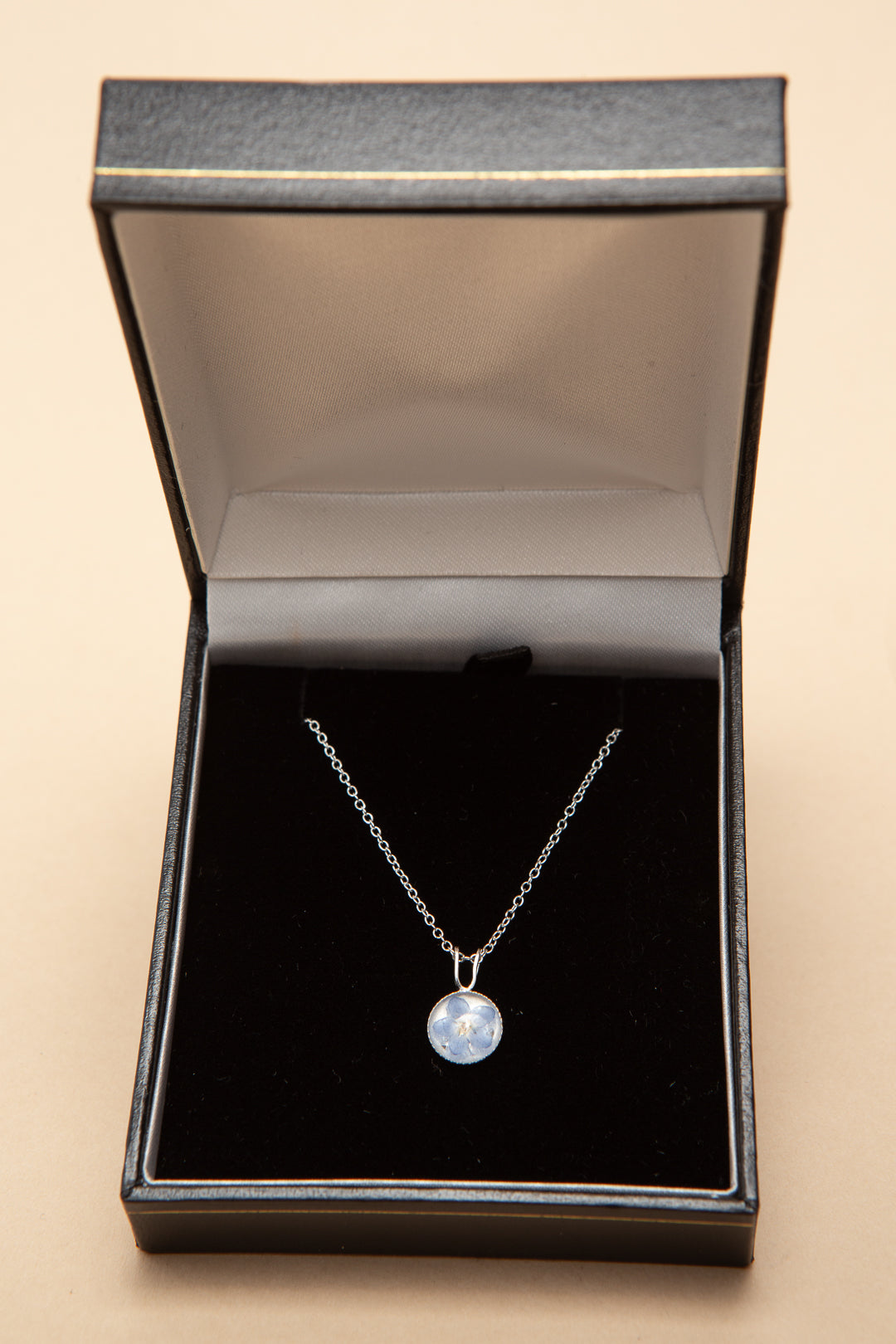 Small sterling silver necklace containing a real forget me not.