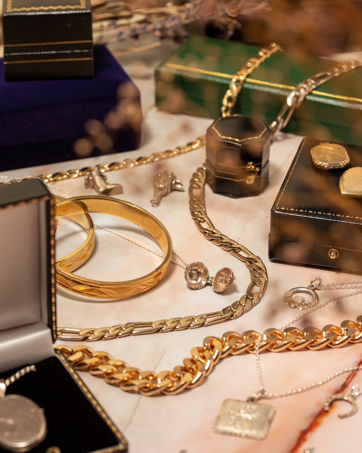 An array of vintage jewellery including chains, bracelets, charms, lockets, rings and necklaces